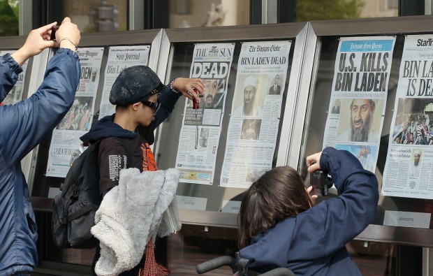 Passers-by take pictures of newspaper headlines reporting the death of Osama Bin Laden, in front of the Newseum, on May 2, 2011 in Washington, DC. (Mark Wilson/Getty Images)
