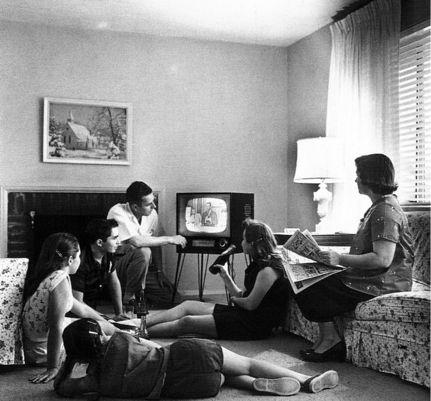 A family gathered in front of a television set, photo by Evert F. Baumgardner, ca. 1958