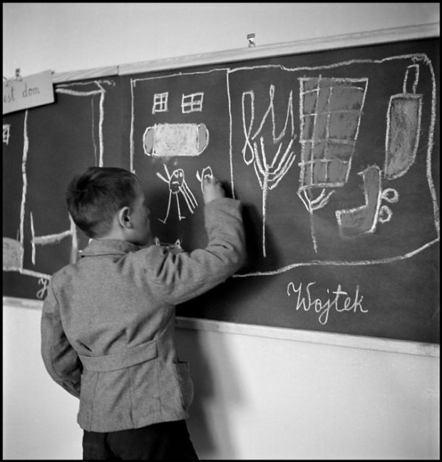 “POLAND. Warsaw. 1948. In a school for mentally disturbed children, one of them, Wojtek, draws his home on a blackboard” by David Seymour. Magnum Image Reference SED1948029W00010/5-110 (NYC122328). © The Estate of David Seymour.